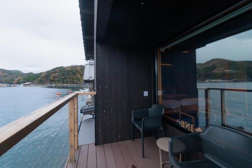 a balcony of a boat with a view of the water at Funaya Raku 樂 in Kameshima