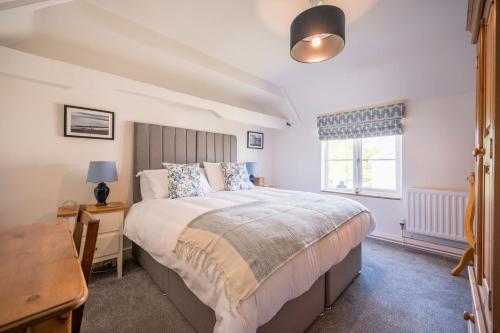 een slaapkamer met een groot bed en een raam bij Stable Cottage, Friston in Friston