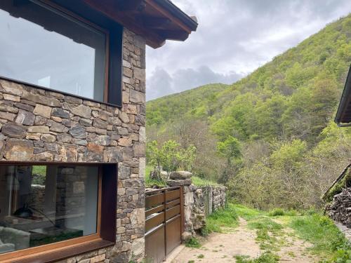 a stone house with a view of a mountain at La era de Somaniezo in Luriezo