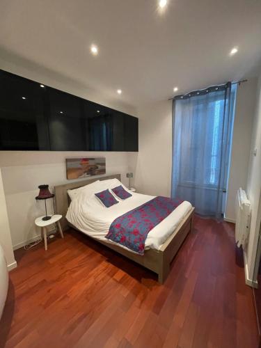 une chambre avec un lit et un parquet dans l'établissement Appartement grand confort au cœur de Millau, à Millau