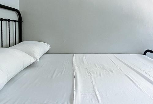 a white bed sitting in a room with a wall at RedDoorz at Aurea Apartelle in Iloilo City