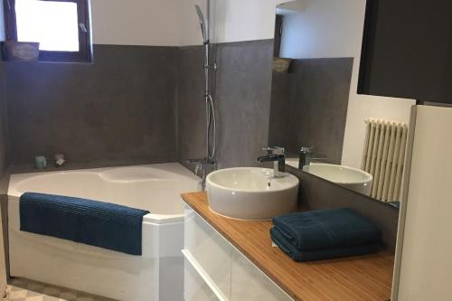 une salle de bain avec un lavabo et une baignoire et un lavabo dans l'établissement Cosy Chalet - Centre village, au calme, à Vallouise