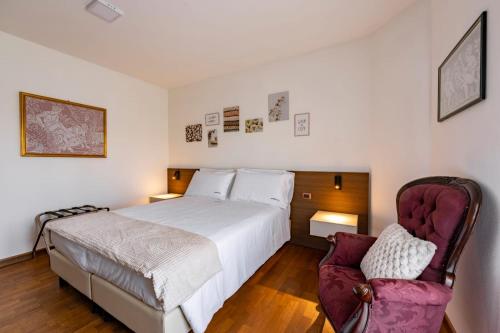 a bedroom with a large bed and two chairs at Due Maestà Home in Reggio Emilia