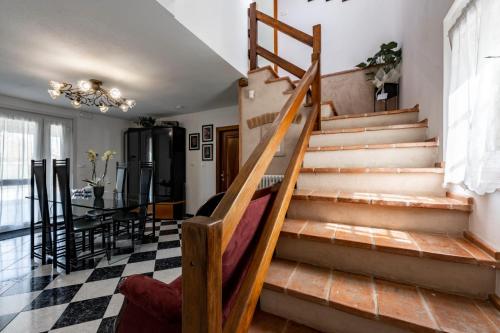 a staircase in a living room with a checkered floor at Due Maestà Home in Reggio Emilia