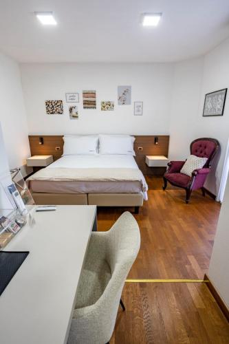 a bedroom with a bed and a desk and a chair at Due Maestà Home in Reggio Emilia