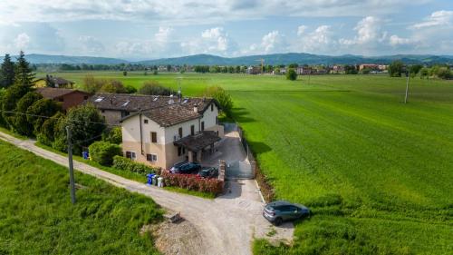 a house in the middle of a green field at Due Maestà Home in Reggio Emilia