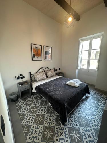 a bedroom with a bed with a black comforter at Iris -Paola Modern Townhouse in Paola