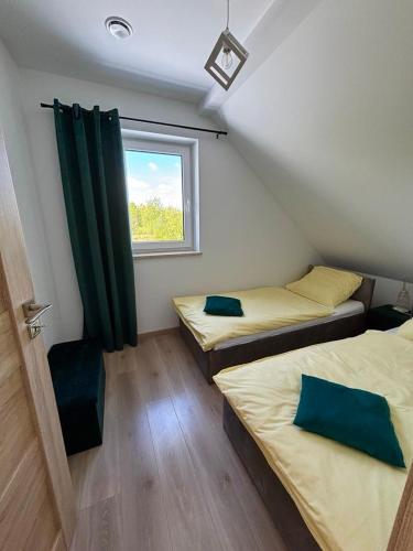 two beds in a room with a window at Apartamenty Gajewscy in Lipnica Górna