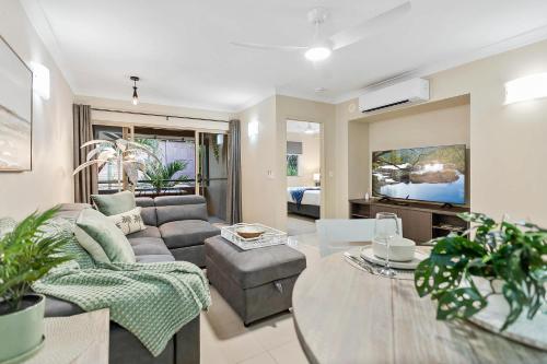 a living room with a couch and a table at Palmview Heights - 9 Pools BBQ & Gym in Westcourt