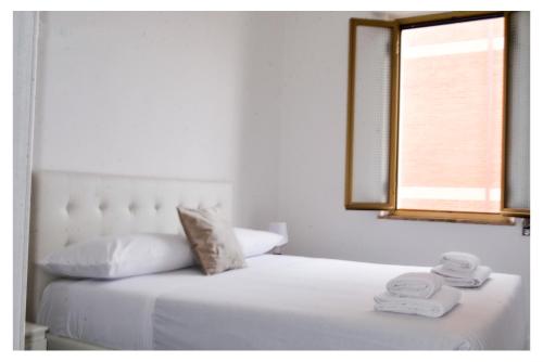 a bedroom with a white bed with towels on it at Ostia Holiday Circe in Lido di Ostia