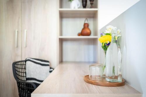 a wooden table with a vase with flowers in it at Rafiki Bush Lodge in Hoedspruit