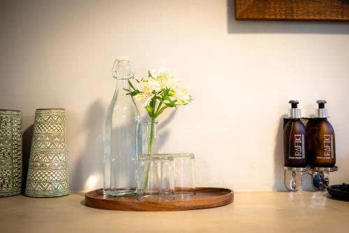 a glass bottle with flowers in a vase on a table at Rafiki Bush Lodge in Hoedspruit