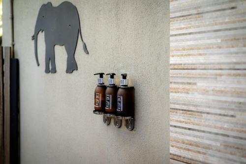 a wall with four bottles of oil on it at Rafiki Bush Lodge in Hoedspruit