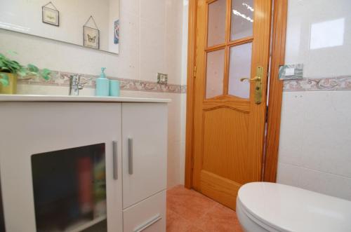 a bathroom with a toilet and a sink and a door at Villa Vargas Paraiso in Carrizal