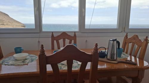 a dining room table with a table and chairs and windows at Villa Vargas Paraiso in Carrizal