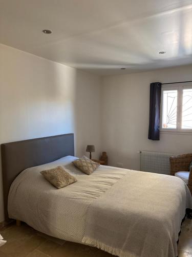 une chambre avec un lit avec deux oreillers dessus dans l'établissement Cosy Sarlat, à Sarlat-la-Canéda