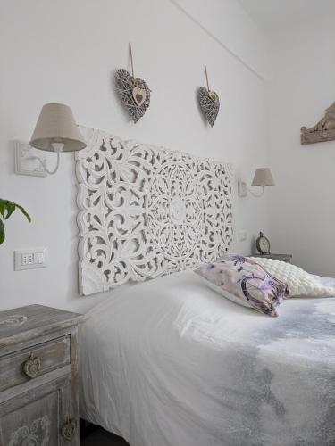 a bedroom with a white bed with a white wall at La porta dell'eden con angolo cottura in Spotorno