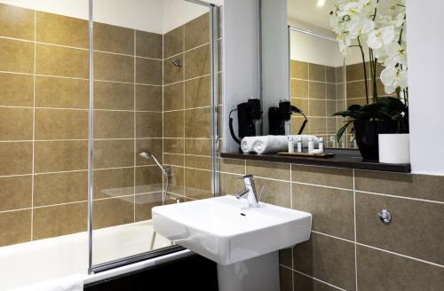 a bathroom with a sink and a mirror at VCity ApartHotels Glasgow Central in Glasgow