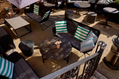 a patio with chairs and a table with a flower on it at Richmond Hill Hotel in Richmond upon Thames