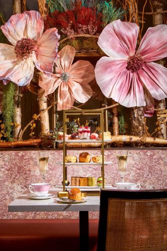 a table with pink flowers on a wall at Richmond Hill Hotel in Richmond upon Thames