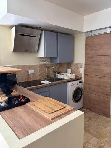 une cuisine avec un évier et une machine à laver dans l'établissement Cosy Sarlat, à Sarlat-la-Canéda