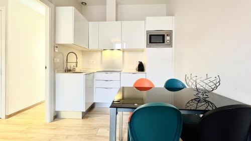 une cuisine avec des armoires blanches et une table et des chaises dans l'établissement Croisette Cannes City center, 100 m from the sea, à La Celle-sous-Gouzon