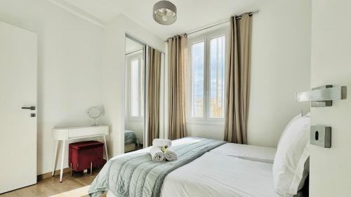 - une chambre blanche avec un lit, un bureau et une fenêtre dans l'établissement Croisette Cannes City center, 100 m from the sea, à La Celle-sous-Gouzon