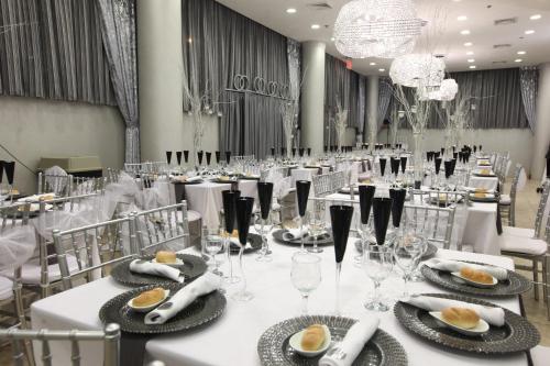 a banquet hall with white tables and chairs and chandeliers at Pointe Plaza Hotel in Brooklyn