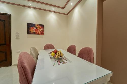 a white table with a bowl of fruit on it at Sand pyramids hotel in Giza