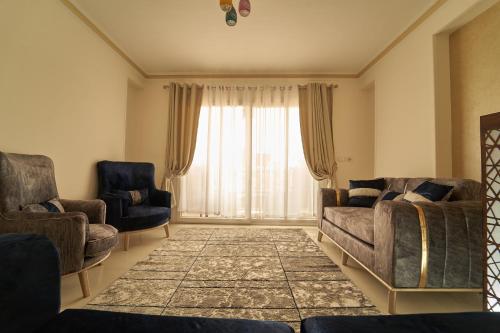 a living room with two couches and a large window at Sand pyramids hotel in Giza
