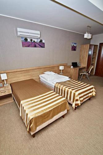 a hotel room with two beds and a desk at Hotel Soccer Sport in Radomsko