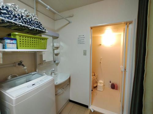 a small bathroom with a sink and a washing machine at SECRET BASE Station Side in Osaka
