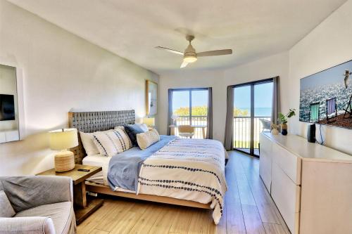 a bedroom with a bed and a couch at Land's End 11-203 Beach Front - Premier in St Pete Beach