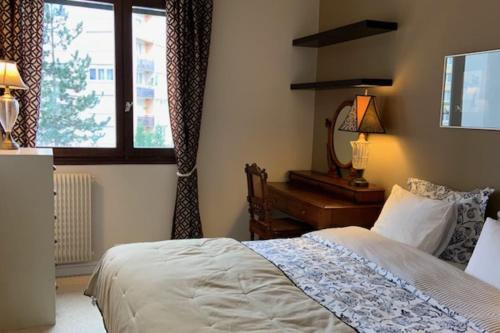 une chambre avec un lit, un bureau et une fenêtre dans l'établissement Island of calm of 90 m2 at the gates of Paris, à Puteaux