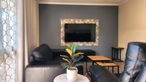 a living room with a couch and a television at The Ranolf Residence in Rotorua