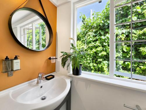 a bathroom with a sink and a mirror and a window at The Loft on Tudor in Tokai