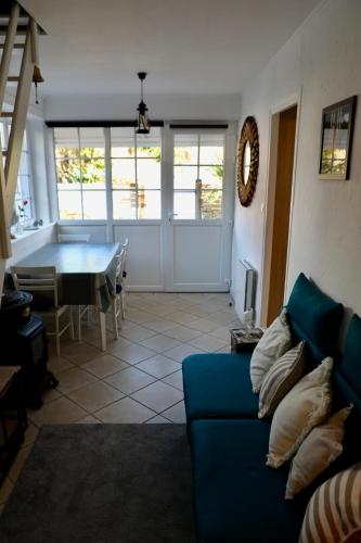 un salon avec un canapé bleu et une table dans l'établissement Grains de Sable, à Barneville-Carteret