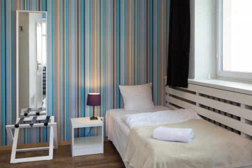 a bedroom with a bed and a table with a lamp at Hotel Traffic Poznań Stare Miasto in Poznań