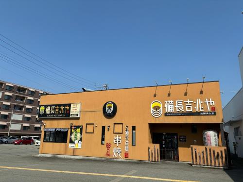 a building with signs on the side of it at 楓の宿 高山市中心 新改装三卧室独栋住宅 周边多个大型超市 至星巴克步行六分钟 两个免费停车位 in Takayama