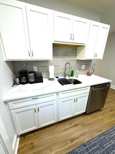 a kitchen with white cabinets and a sink at Cozy Walk up King Bed fast WiFi in Wilmington