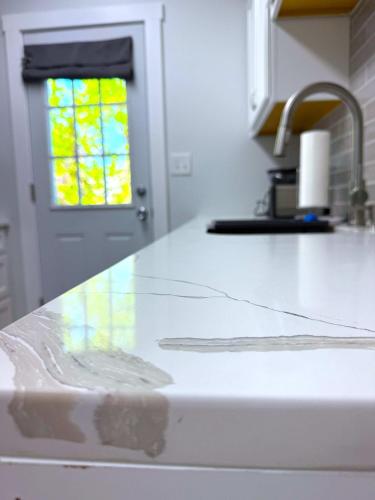 a white counter top in a kitchen with a window at Cozy Walk up King Bed fast WiFi in Wilmington