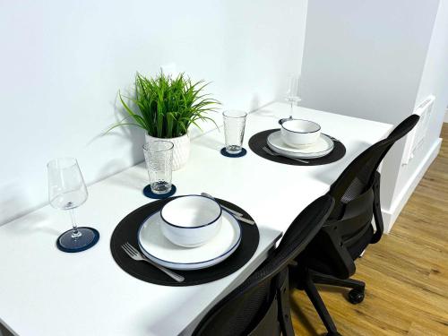 a white table with black chairs and plates and wine glasses at Cozy Walk up King Bed fast WiFi in Wilmington