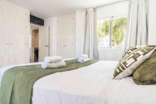 a bedroom with a large bed with towels on it at Exclusive Villa, private pool, BBQ and beach access REMS in Torremolinos