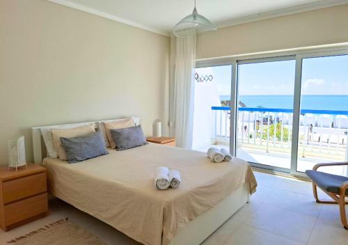 a bedroom with a bed with a view of the ocean at Praia da Rocha in Portimão
