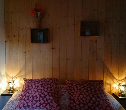 a bedroom with a bed with a wooden wall at Chambre paisible avec jardin à la campagne en Finistère sud in Scaër