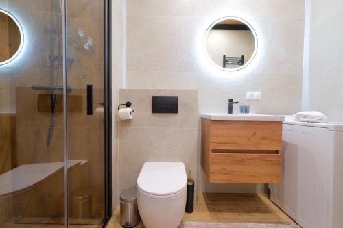 a bathroom with a toilet and a shower and a sink at Laguna Beskidów Resort - Apartament E59 in Zarzecze