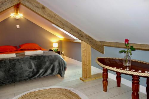 une chambre avec un grand lit et une table dans l'établissement Grains de Sable, à Barneville-Carteret