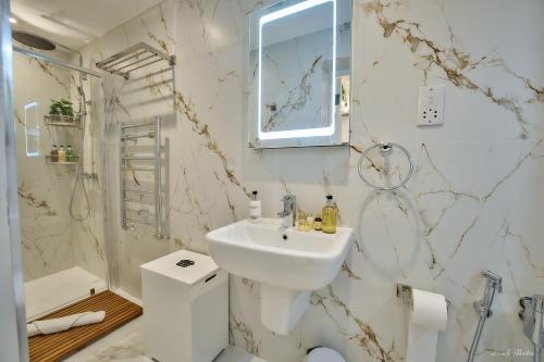 a white bathroom with a sink and a toilet at Luxury Studio in Wembley in Wembley