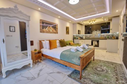 a bedroom with a king sized bed and a kitchen at Luxury Studio in Wembley in Wembley