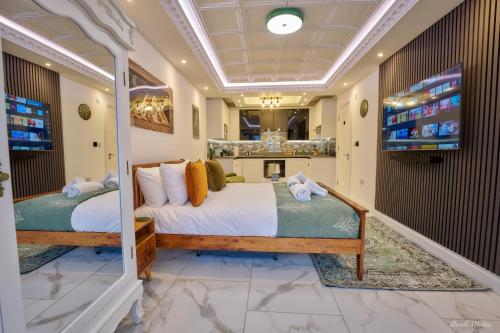 a bedroom with two beds and a fireplace at Luxury Studio in Wembley in Wembley